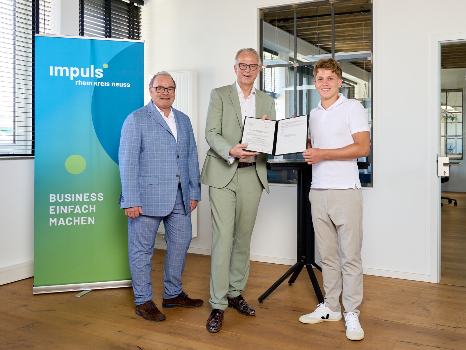 Übergabe des Förderbescheids für das Programm accelerate_rkn der impuls.RheinKreisNeuss Wirtschaftsförderung an einen der Neybor-Gründer
